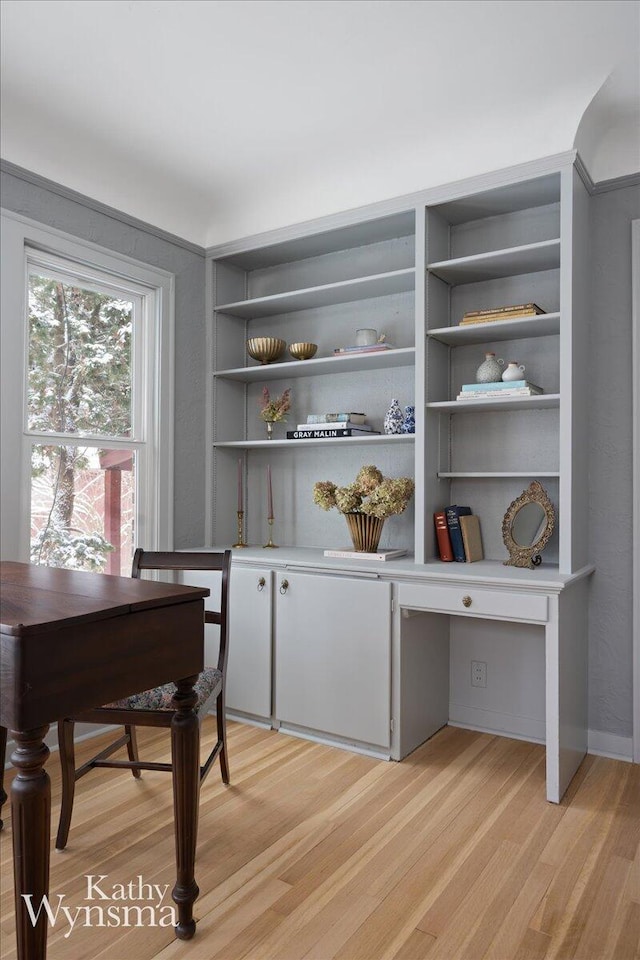 office area with built in desk and light wood-style flooring