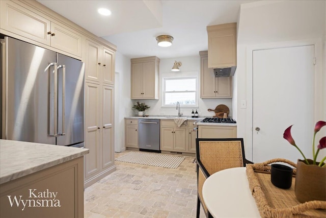 kitchen featuring stainless steel appliances, recessed lighting, cream cabinetry, and a sink