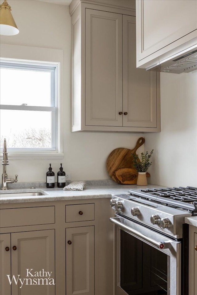 kitchen featuring light countertops, a sink, and stainless steel stove