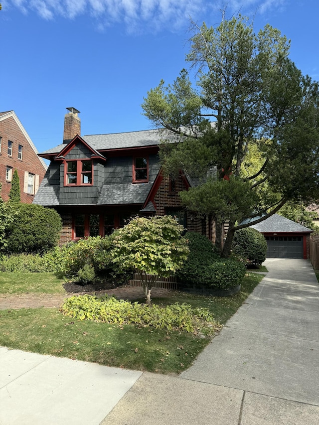 view of front of house featuring an outbuilding, a detached garage, and a chimney