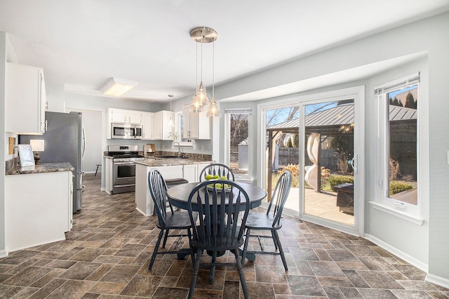 dining room featuring stone finish flooring and baseboards