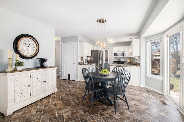 dining space featuring stone finish floor and baseboards