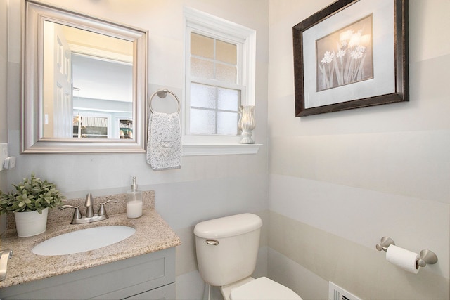 half bath featuring toilet, a baseboard radiator, and vanity