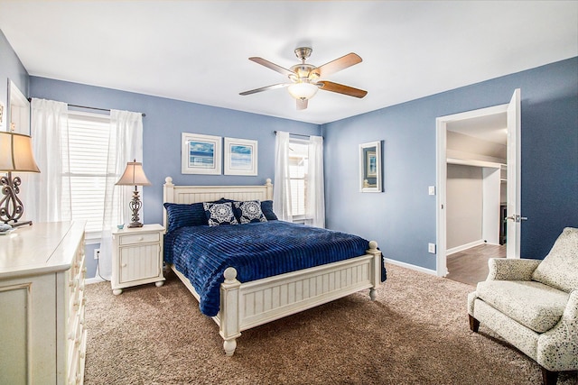 bedroom with ceiling fan, carpet floors, a walk in closet, and baseboards