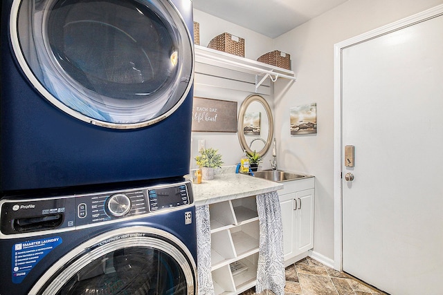 laundry room with stacked washer and dryer, stone finish floor, and cabinet space