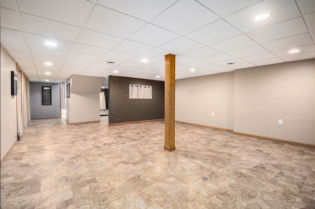 finished below grade area with baseboards, a drop ceiling, and recessed lighting