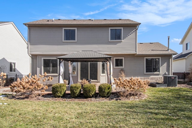 rear view of house featuring fence, cooling unit, a lawn, and a gazebo