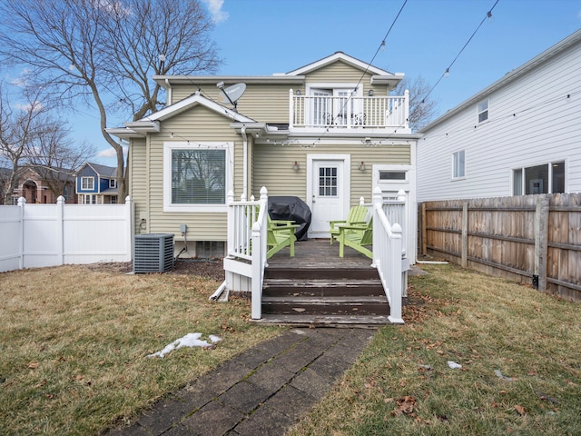 back of house with a lawn, a balcony, a fenced backyard, cooling unit, and a wooden deck