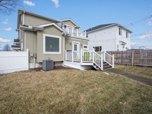 back of house featuring a balcony, central air condition unit, a fenced backyard, and a lawn