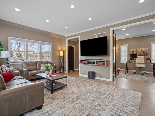 living area featuring light wood-style flooring, recessed lighting, visible vents, baseboards, and ornamental molding