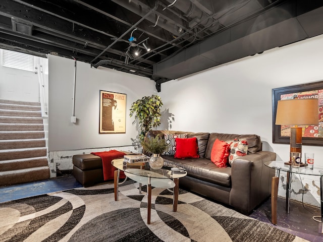 living room featuring concrete flooring and stairway