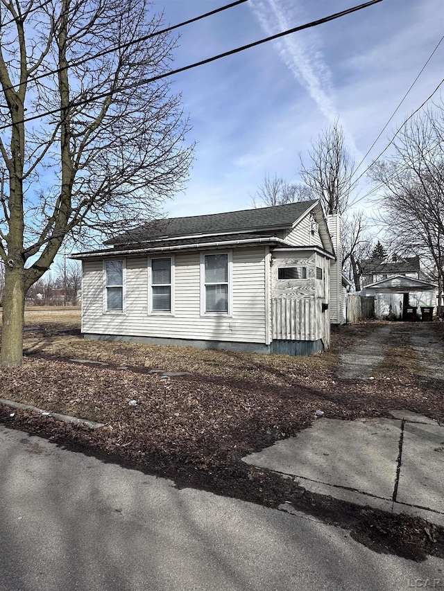 view of property exterior with roof with shingles