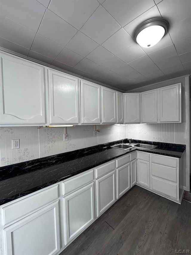 kitchen with dark wood-style floors, white cabinetry, and a sink