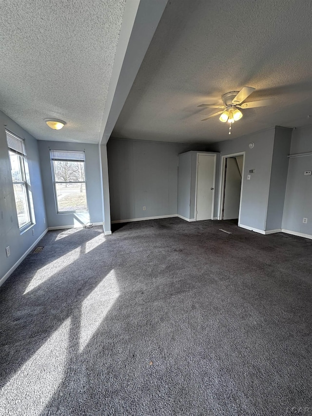 unfurnished living room with baseboards and a textured ceiling