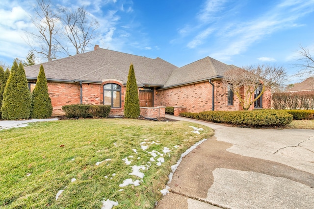 french country inspired facade with brick siding, a front lawn, and a shingled roof