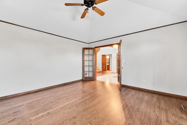 empty room featuring baseboards, high vaulted ceiling, ceiling fan, and wood finished floors