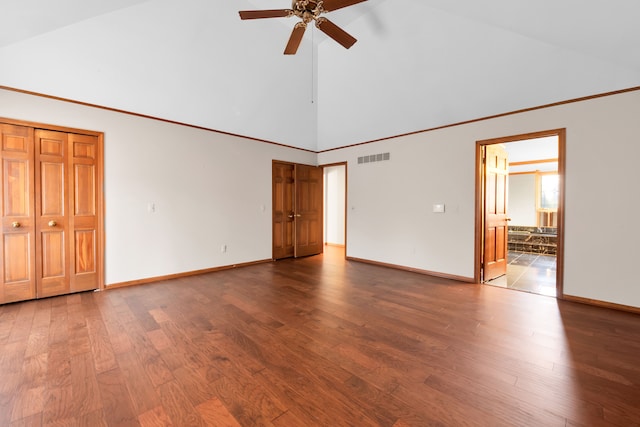 unfurnished bedroom with baseboards, visible vents, ensuite bath, wood finished floors, and high vaulted ceiling