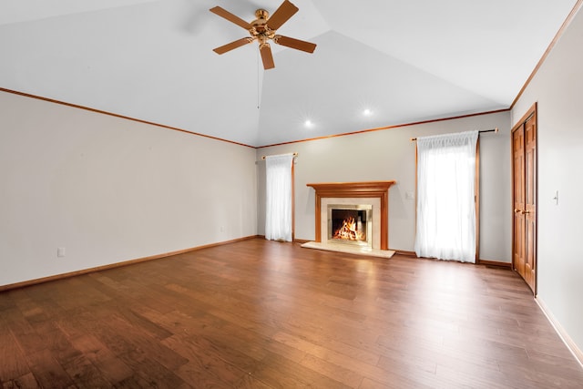 unfurnished living room featuring a warm lit fireplace, baseboards, ornamental molding, and wood finished floors