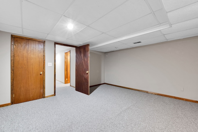 unfurnished room with carpet flooring, baseboards, visible vents, and a drop ceiling