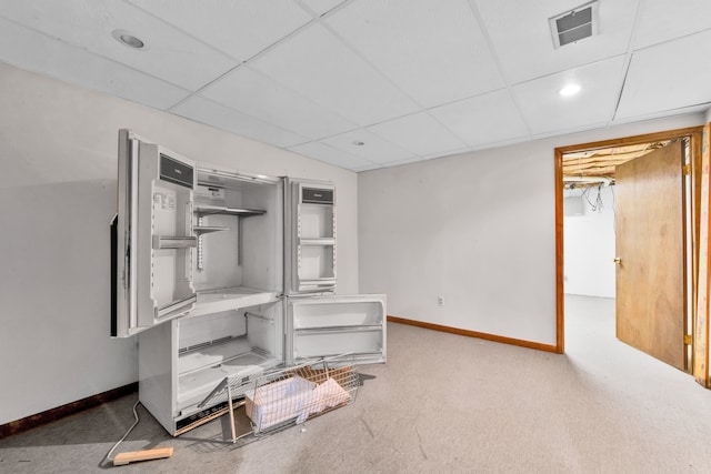 interior space featuring a drop ceiling, carpet flooring, visible vents, and baseboards