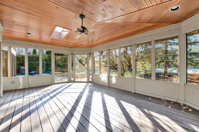 unfurnished sunroom featuring a ceiling fan, vaulted ceiling with skylight, and wooden ceiling