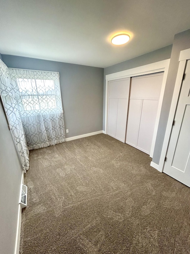 unfurnished bedroom featuring carpet floors, a closet, and baseboards