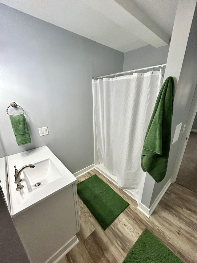 full bathroom featuring baseboards, wood finished floors, vanity, and a shower with curtain