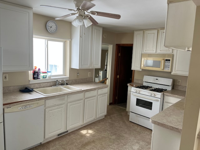 kitchen with white appliances, visible vents, a ceiling fan, light countertops, and a sink