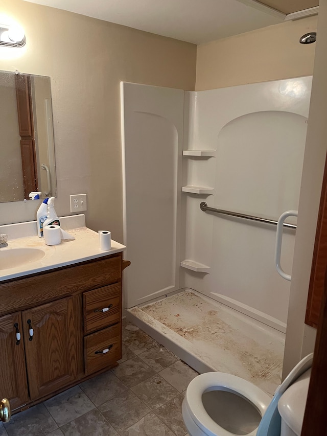 bathroom with a walk in shower, toilet, and vanity