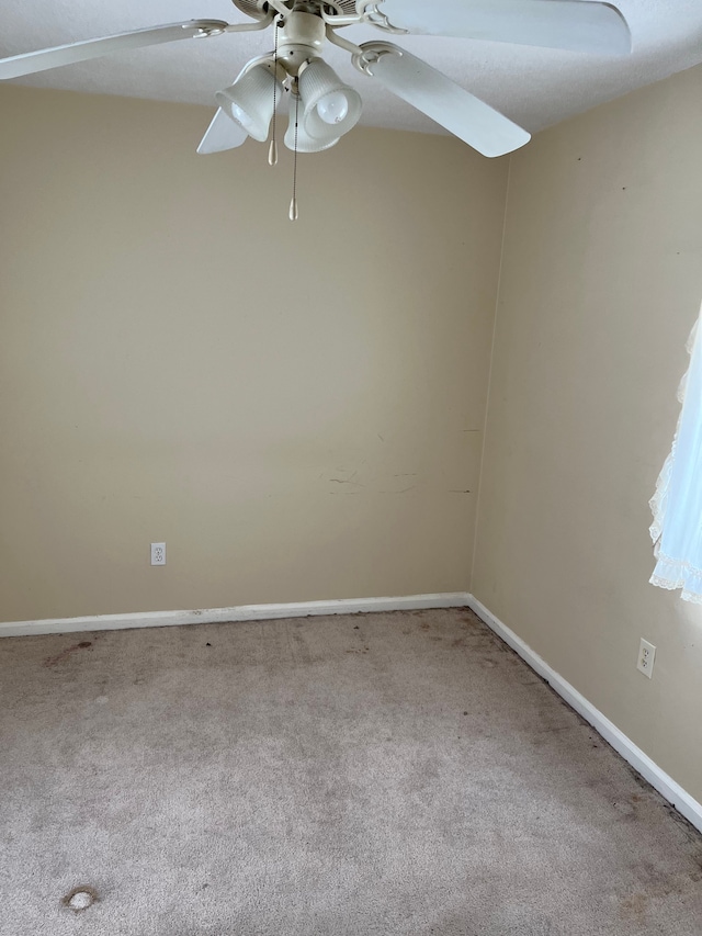 empty room with carpet floors, baseboards, and a ceiling fan