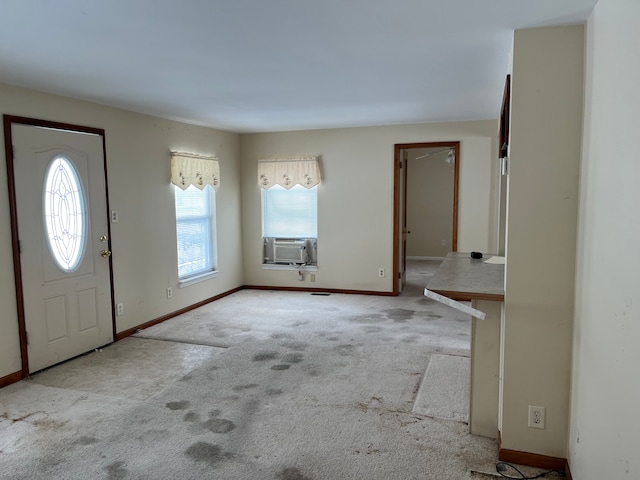 entrance foyer featuring cooling unit, carpet flooring, and baseboards