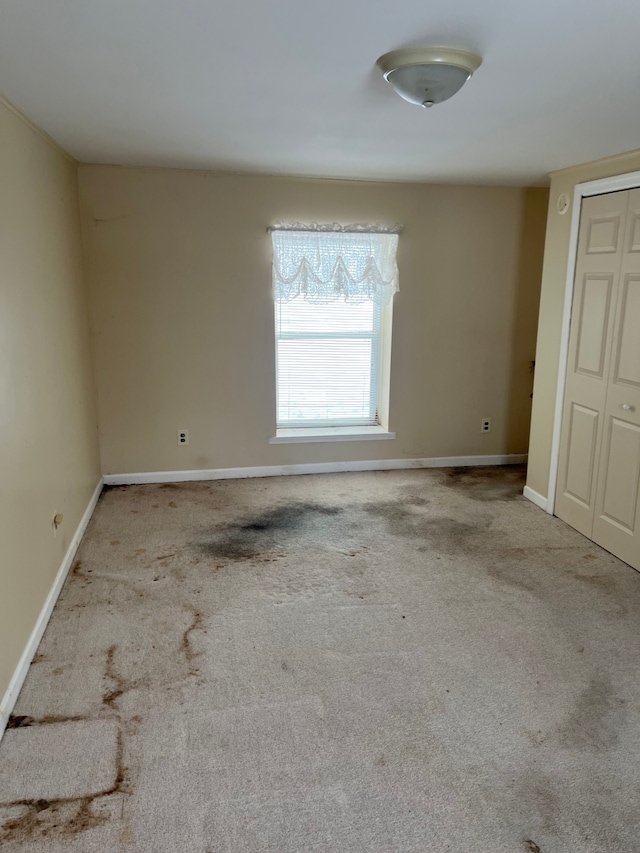 carpeted spare room with baseboards