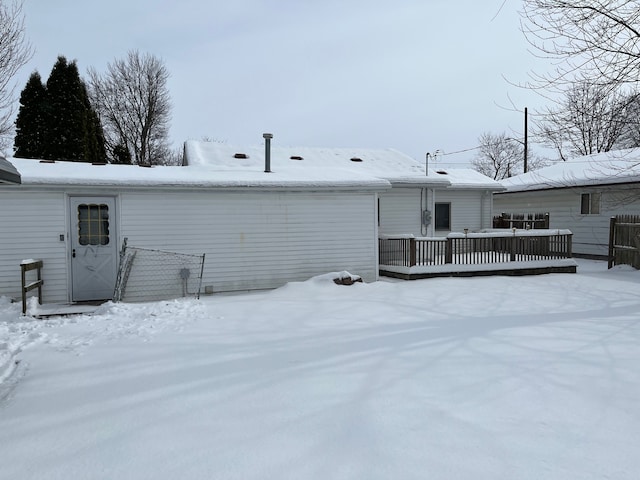 snow covered rear of property featuring a wooden deck