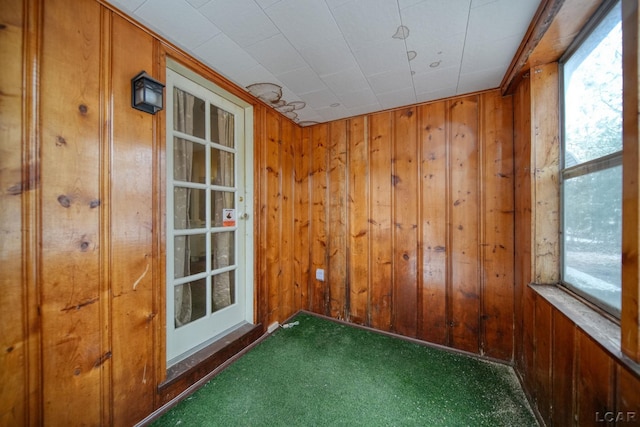 empty room with carpet and wooden walls