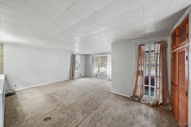 carpeted empty room featuring baseboards