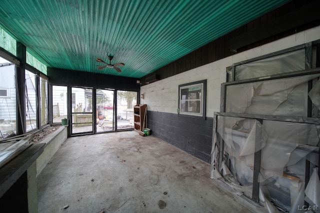 unfurnished sunroom featuring a ceiling fan