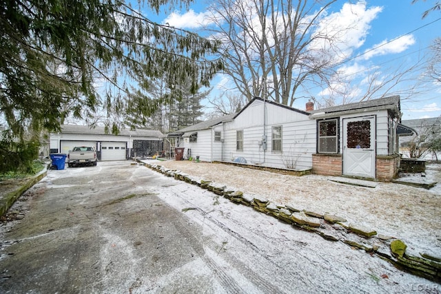 view of front of house featuring a garage, an outbuilding, and a chimney