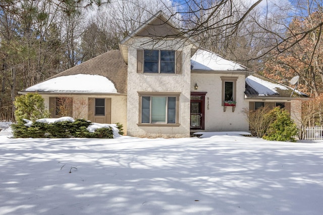 view of front of property featuring roof with shingles and stucco siding