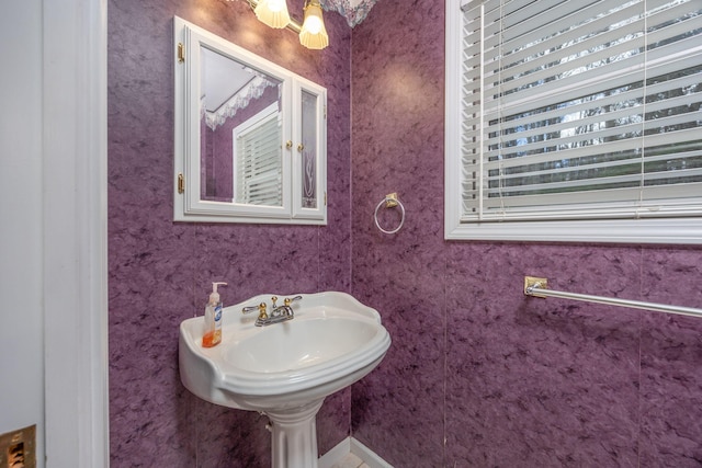 bathroom with a sink and wallpapered walls