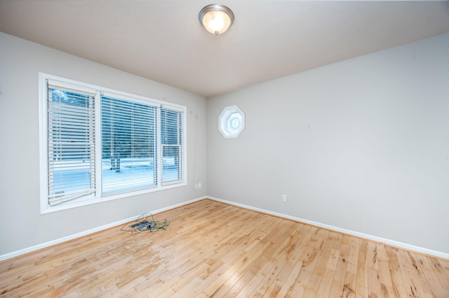 empty room with hardwood / wood-style floors and baseboards