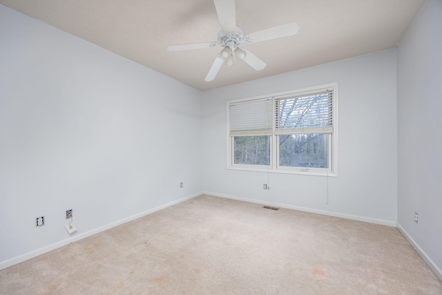 unfurnished room with baseboards, visible vents, a ceiling fan, and light colored carpet