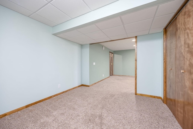 interior space featuring a drop ceiling, carpet flooring, and baseboards