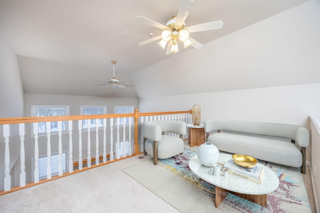 living area featuring lofted ceiling, ceiling fan, and carpet flooring