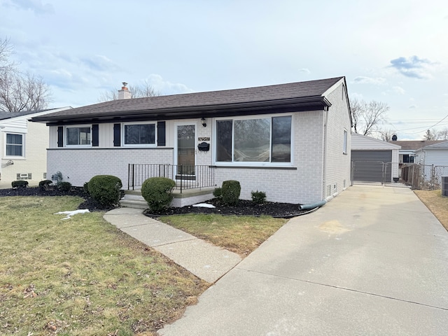 view of front facade featuring an outbuilding, brick siding, a detached garage, a chimney, and a front yard