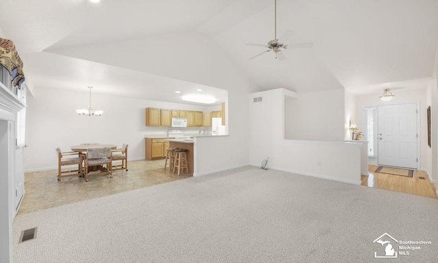 unfurnished living room featuring high vaulted ceiling, light carpet, ceiling fan with notable chandelier, visible vents, and baseboards