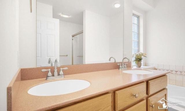 full bath with double vanity, a sink, and a tub