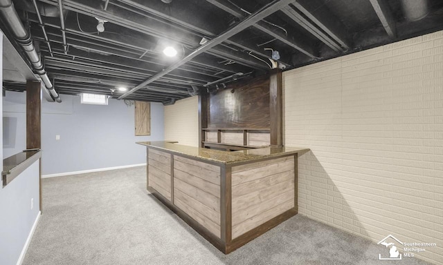 basement featuring brick wall and carpet