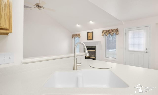 details with light countertops, visible vents, a premium fireplace, a ceiling fan, and a sink