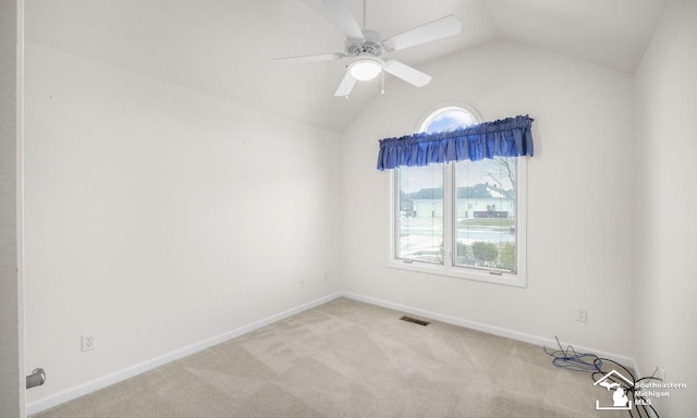 unfurnished room featuring carpet, visible vents, vaulted ceiling, ceiling fan, and baseboards