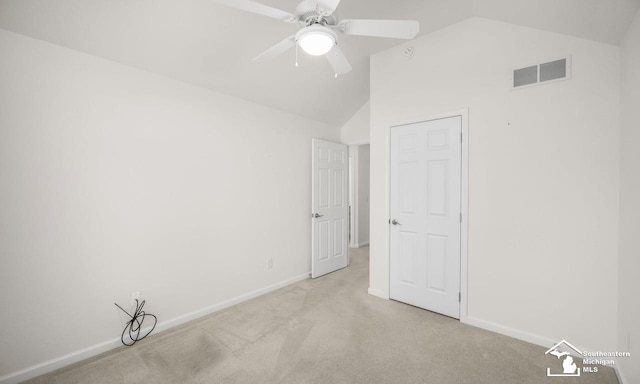 unfurnished bedroom featuring lofted ceiling, baseboards, visible vents, and light colored carpet